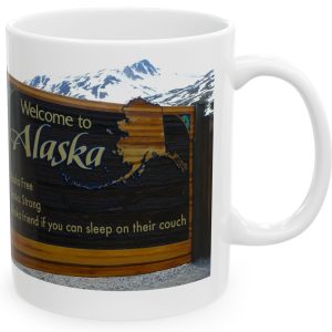 White Mug with fake state motto for Alaska: "Alaska Free, Alaska Strong, Alaska Friend if You Can Sleep on Their Couch."