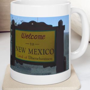White Mug with fake state motto for New Mexico: "Land of Disenchantment."