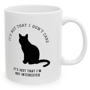 White Mug with the black image of a cat and the saying, "It's not that I don't care, it's just that I'm not interested."